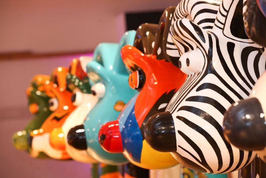 the faces of 7 gromit statues, painted as different things, side by side